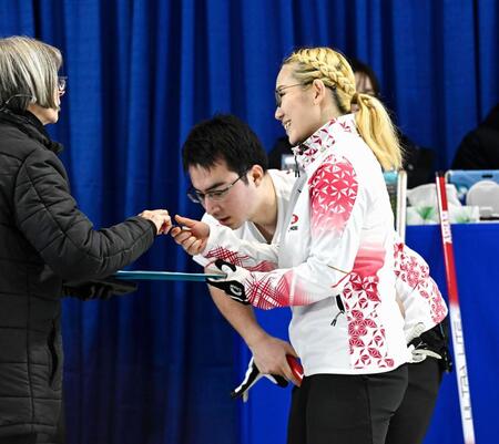 　混合ダブルス１次Ｌでトルコに勝利し、笑顔を見せる小穴桃里。奥は青木豪（共同）