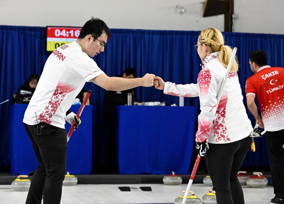 　混合ダブルス１次Ｌでトルコに勝利し、小穴桃里（右）とタッチを交わす青木豪（共同）