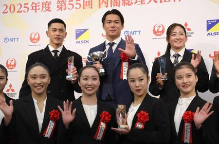 　受賞者と並んで手を振る山本（中央）＝１７日