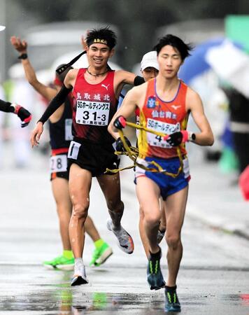 　３区を走り終え、たすきをつなぐ鳥取城北・村上遵世（左）＝撮影・山口登
