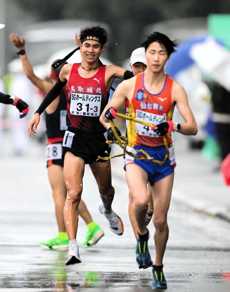 　３区を走り終え、たすきをつなぐ鳥取城北・村上遵世（左）＝撮影・山口登