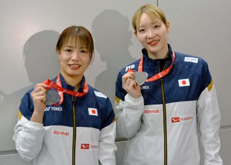 　メダルを手に写真に納まるバドミントン女子ダブルスの福島由紀（左）と松本麻佑＝２２日、成田空港