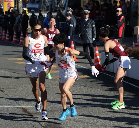 　２位で中大・本間颯にたすきを渡す中大・溜池一太（撮影・金田祐二）