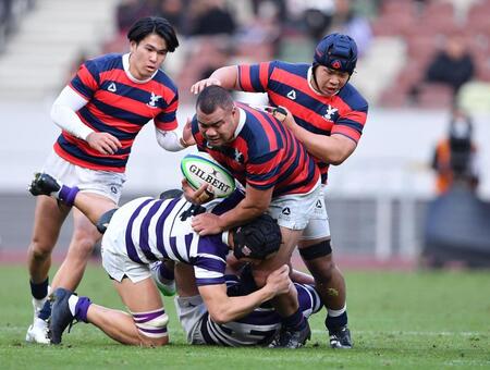 　前半、明大の強烈なタックルを受ける京産大・ボルテレ（撮影・開出牧）