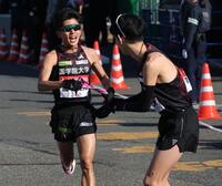 　野中恒亨にたすきをわたす国学院大・上原琉翔（撮影・金田祐二）
