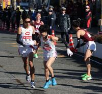 　２位で中大・本間颯にたすきを渡す中大・溜池一太（撮影・金田祐二）