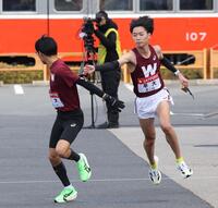 　５区・工藤慎作（左）へタスキをつなぐ早大４区・鈴木琉胤（撮影・佐々木彰尚）