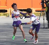 　駒大４区・村上響（左）から５区・安原海晴へタスキをつなぐ（撮影・佐々木彰尚）