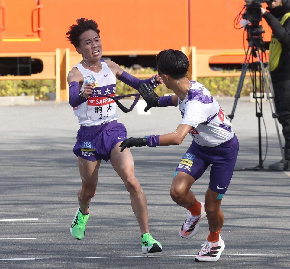 　駒大４区・村上響（左）から５区・安原海晴へタスキをつなぐ（撮影・佐々木彰尚）