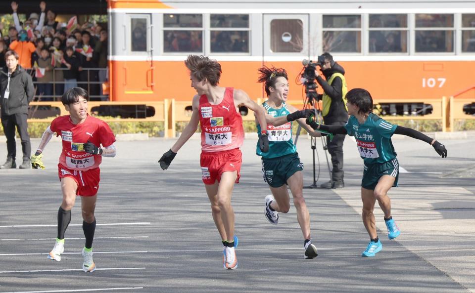 　城西大４区・桜井優我（左から２人目）から５区・斎藤将也（左）へ。青学大４区・平松享祐（右から２人目）から５区・黒田朝日へタスキをつなぐ（撮影・佐々木彰尚）