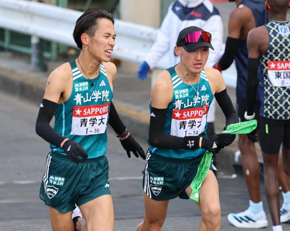 　鶴見中継所で小河原陽琉（左）からタスキを受ける青学大・飯田翔太