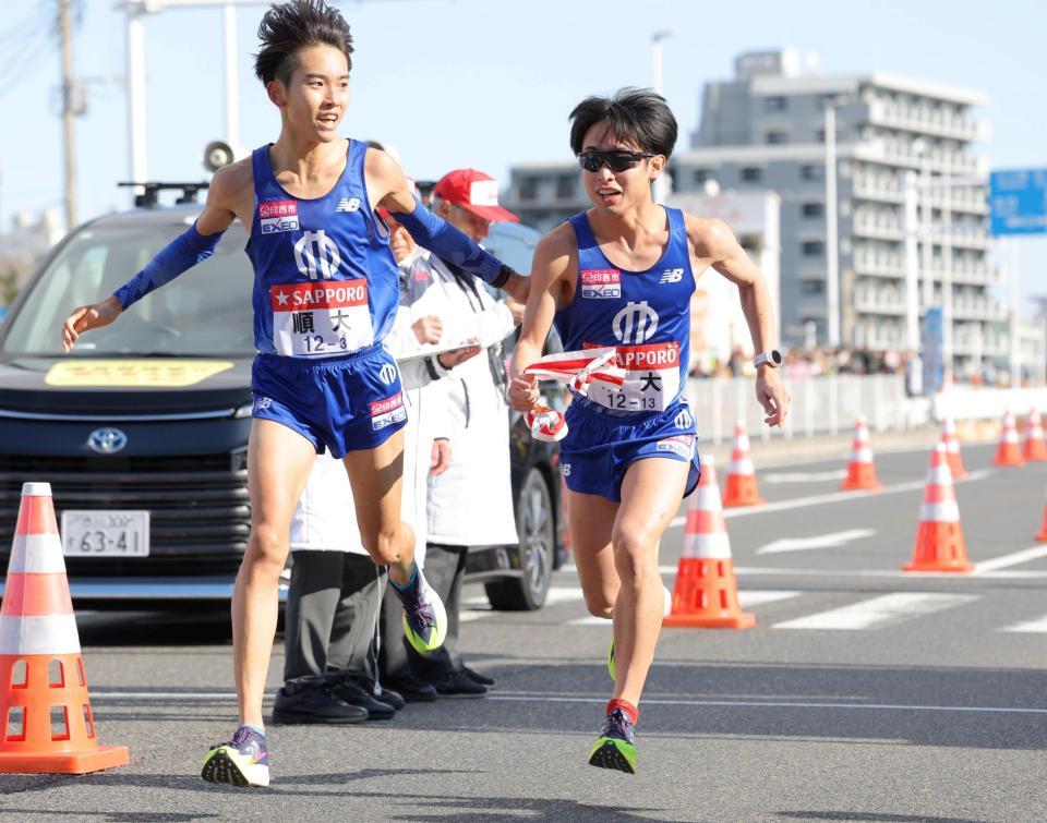 　順大・井上朋哉（左）から川原琉人へたすきを繫ぐ（代表撮影）