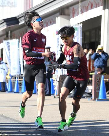 　たすきをつなぐ早大・山崎一吹と間瀬田純平（撮影・伊藤笙子）