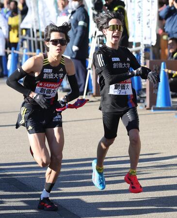 　７区の石丸惇那にたすきをつなぐ創価大６区の小池莉希（右）