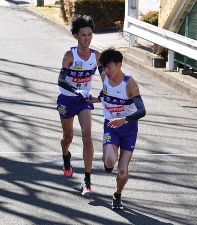 　たすきをつなぐ駒大・菅谷希弥（左）と佐藤圭汰（撮影・開出牧）