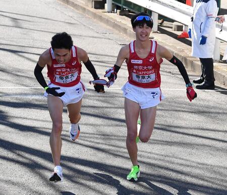 　たすきをつなぐ帝京大・尾崎仁哉（左）と鎗田大輝（撮影・開出牧）