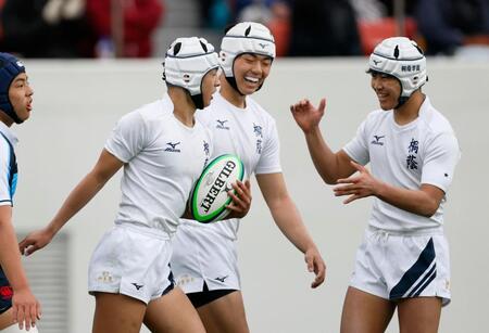 　前半、トライを決め、祝福される桐蔭学園・鈴木（左）