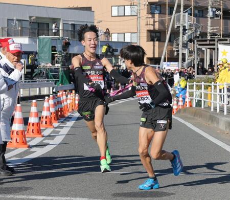 　平塚中継所で、飯国新太（右）にたすきを繫ぐ国学院大・高山豪起（撮影・吉澤敬太）