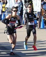 　７区の石丸惇那にたすきをつなぐ創価大６区の小池莉希（右）