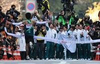 　総合優勝のゴールテープを切る青学大アンカーの折田壮太を迎える原晋監督（奥中央）とチームメートら（代表撮影）