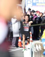 　平塚中継所で待つ飯国新太に向かってたすきを掲げ、ラストスパートする国学院大・高山豪起（撮影・吉澤敬太）