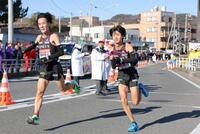 　平塚中継所で、高山豪起（左）からたすきを受け取った国学院大・飯国新太（撮影・吉澤敬太）