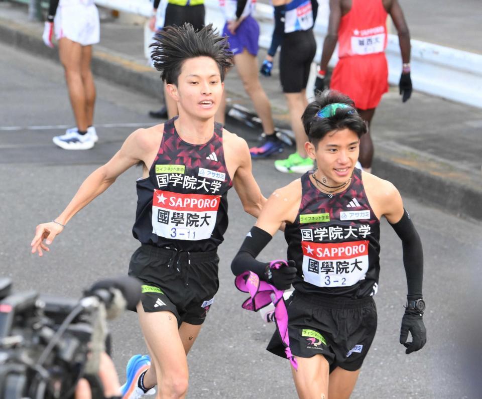 　区間新の快走で２区・上原（右）にタスキをつなぐ国学院大・青木（撮影・伊藤笙子）