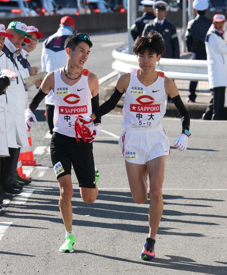 　たすきをつなぐ中大・佐藤大介（左）と吉居駿恭（撮影・金田祐二）
