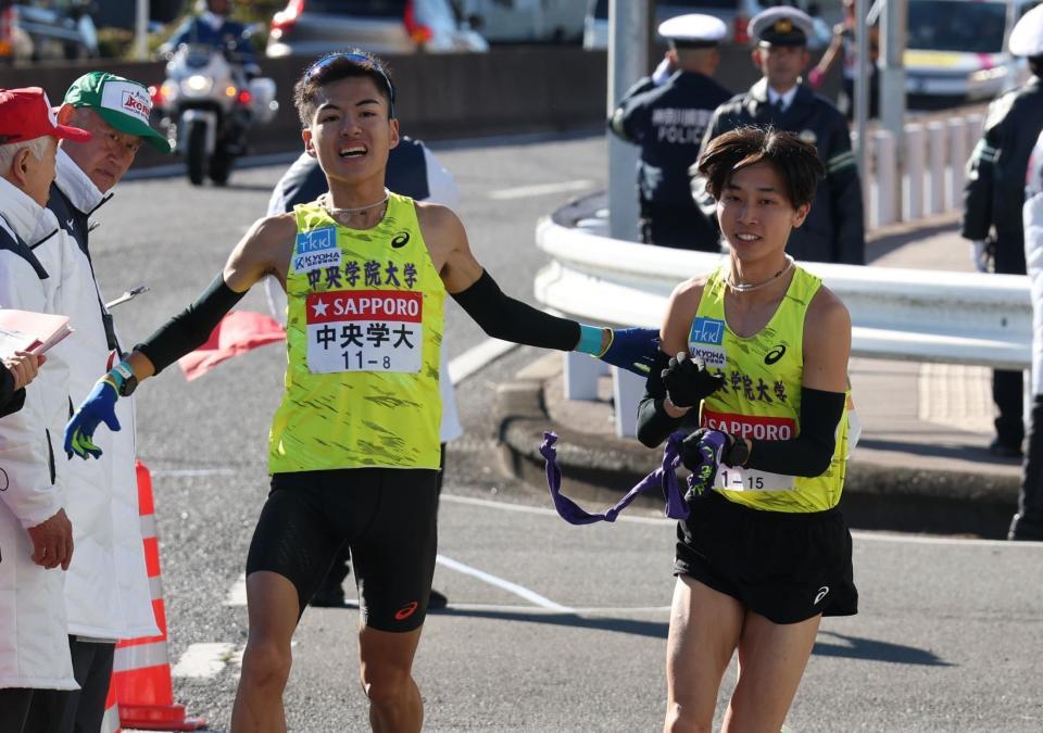 　たすきをつなぐ中央学院大・黒谷優（左）と山中航太（撮影・金田祐二）