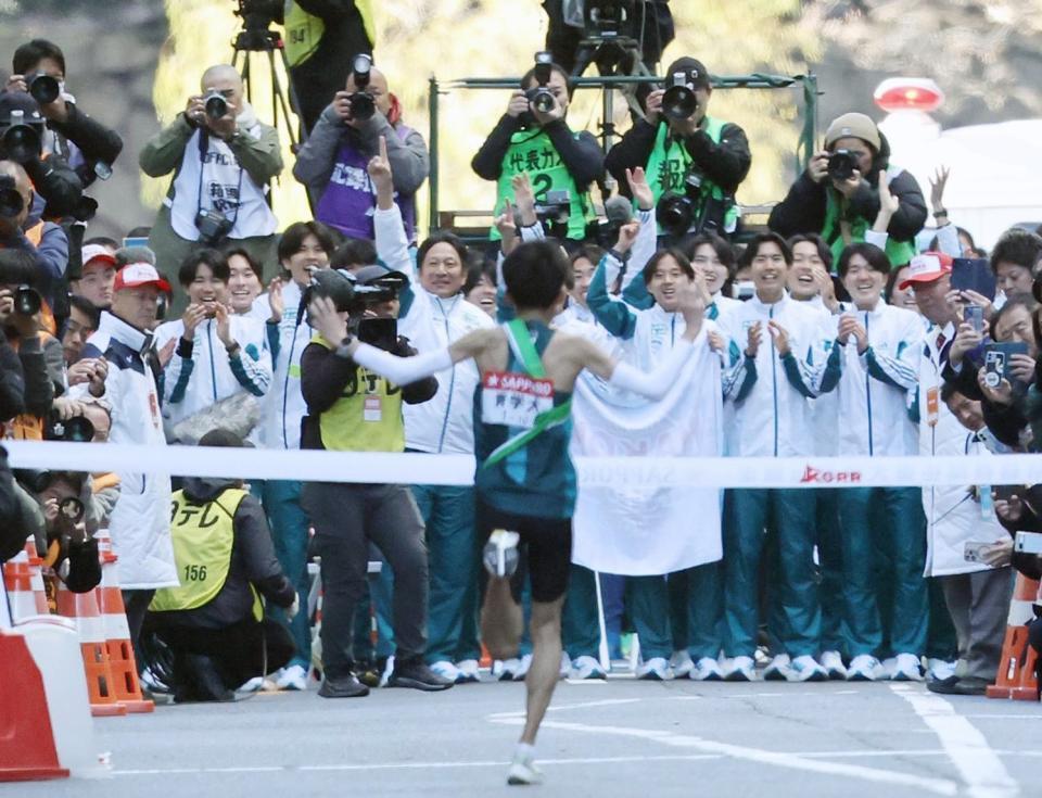 　ゴールするアンカー折田壮太（中央）を迎える青学大の選手ら