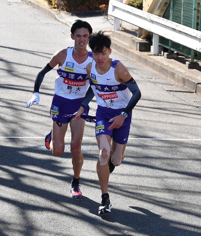 　たすきをつなぐ駒大・菅谷希弥（後方）と佐藤圭汰（撮影・開出牧）