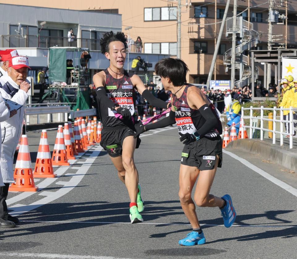 　平塚中継所で、飯国新太（右）にたすきを繫ぐ国学院大・高山豪起（撮影・吉澤敬太）