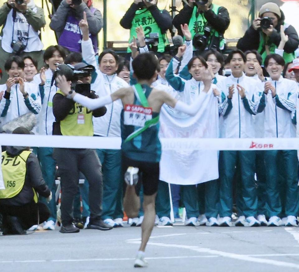 　ゴールするアンカー折田壮太（中央）を迎える青学大の選手ら＝３日
