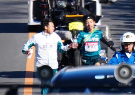 　５区、弟の黒田然（左）から水を受け取る青学大・黒田朝＝２日