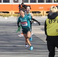 　青学大４区・平松享祐（右）からタスキを受け取り駆け出す５区・黒田朝日＝２日