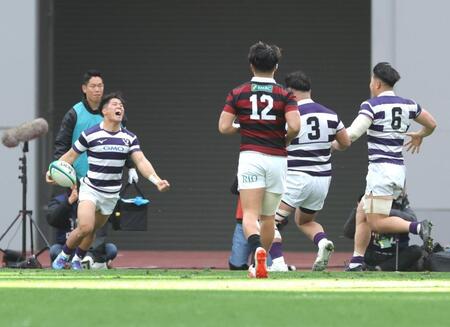 　前半、トライを決め、雄たけびを挙げる明大・伊藤龍之介（左）＝撮影・西岡正