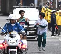 　９区、給水員から飲料を受け取る青学大・田中悠登（左）＝２０２５年１月３日