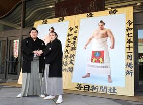 　優勝額贈呈式で写真に納まる大の里（左）と安青錦