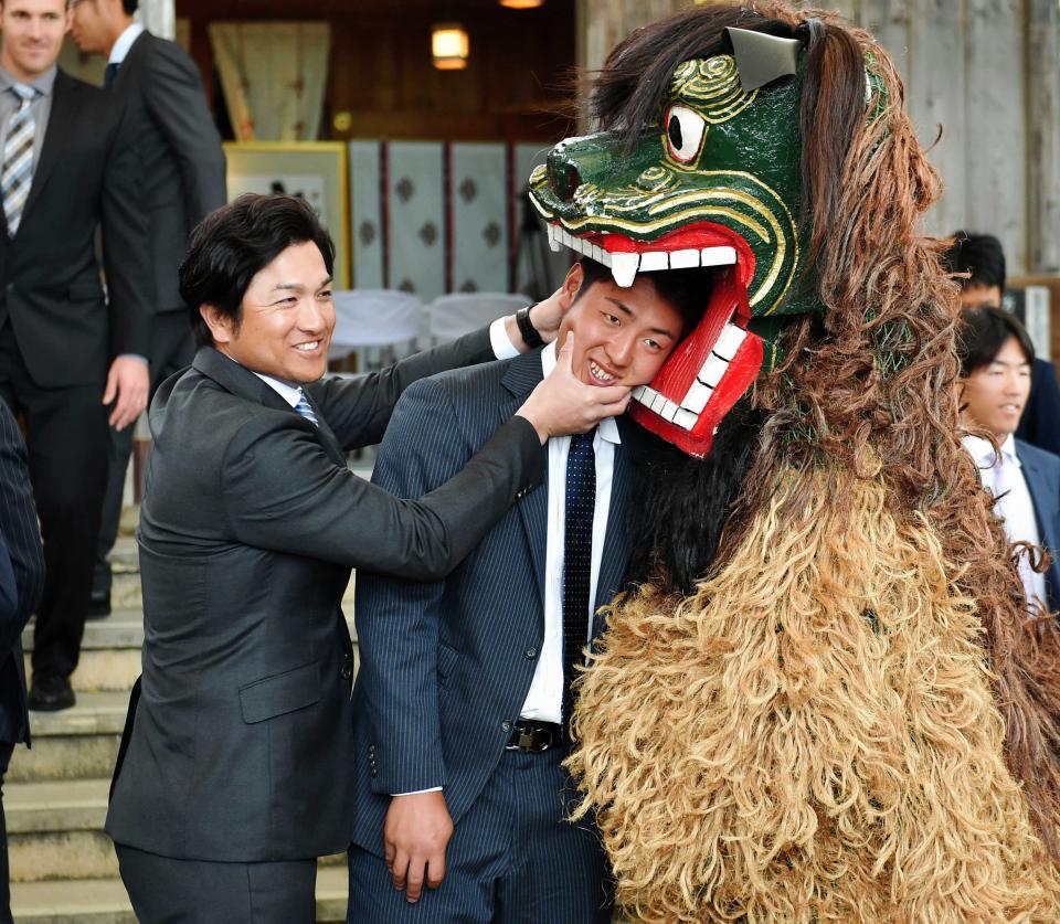 　岡本和（右）を身代わりとして獅子舞の口に押し込める高橋監督（左）＝２０１６年