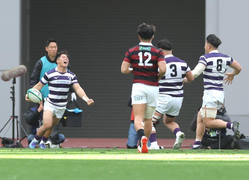 　前半、トライを決め、雄たけびを挙げる明大・伊藤龍之介（左）＝撮影・西岡正