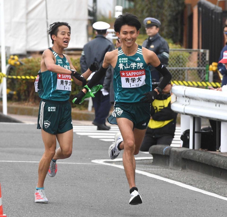　８区の青学大・塩出翔太（左）からたすきをつなぎ駆け出す９区の田中悠登＝２０２５年１月３日