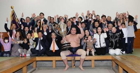 大相撲初場所で優勝し、賜杯を手に笑顔を見せる照ノ富士（中央）。その右は愛息の照務甚（てむじん）君と妻のドルジハンドさん＝２０２４年１月