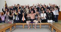 大相撲初場所で優勝し、賜杯を手に笑顔を見せる照ノ富士（中央）。その右は愛息の照務甚（てむじん）君と妻のドルジハンドさん＝２０２４年１月