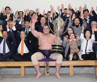 大相撲初場所で優勝し、賜杯を手に笑顔を見せる照ノ富士（中央）。その右は愛息の照務甚（てむじん）君と妻のドルジハンドさん＝２０２４年１月