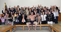 大相撲初場所で優勝し、賜杯を手に笑顔を見せる照ノ富士（中央）。その右は愛息の照務甚（てむじん）君と妻のドルジハンドさん＝２０２４年１月