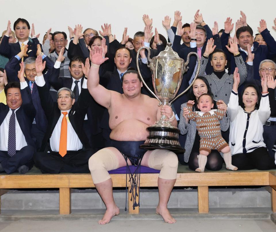 大相撲初場所で優勝し、賜杯を手に笑顔を見せる照ノ富士（中央）。その右は愛息の照務甚（てむじん）君と妻のドルジハンドさん＝２０２４年１月