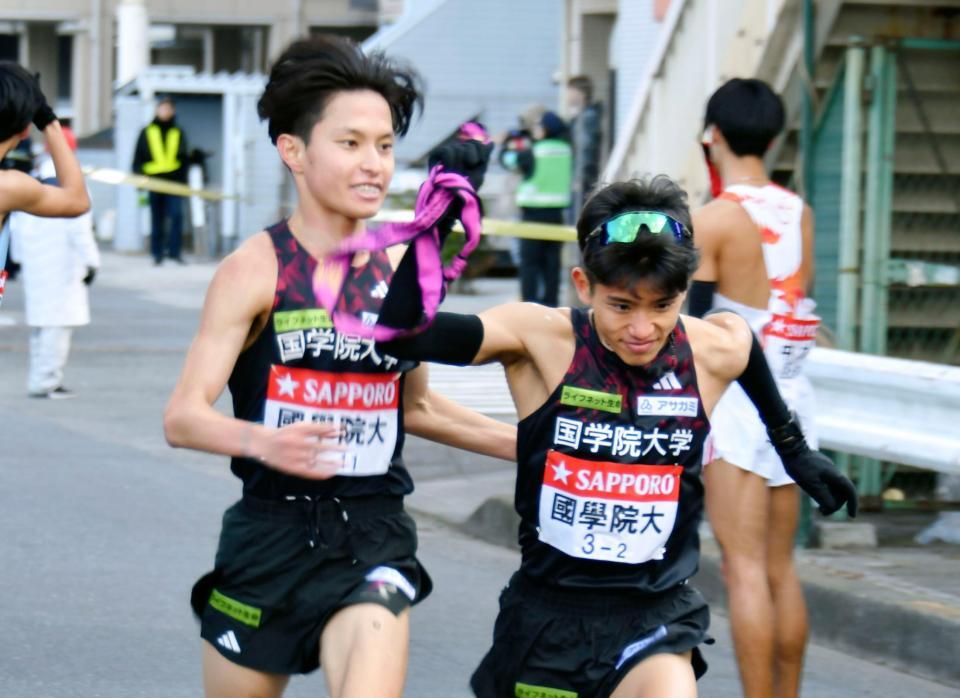 ２区の上原琉翔（右）にたすきをつなぐ国学院大・青木瑠郁＝１月２日