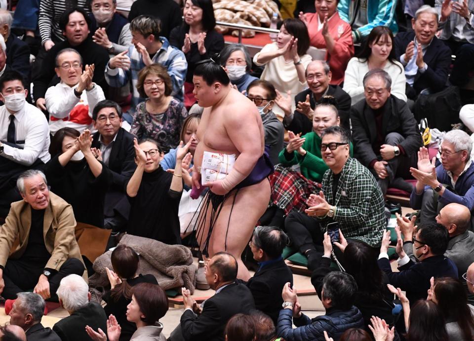 大金星の義ノ富士（中央）がファンの祝福を受ける＝両国国技館（撮影・園田高夫）
