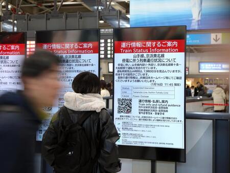 　運航状況を伝える案内を見つめる人（撮影・伊藤笙子）