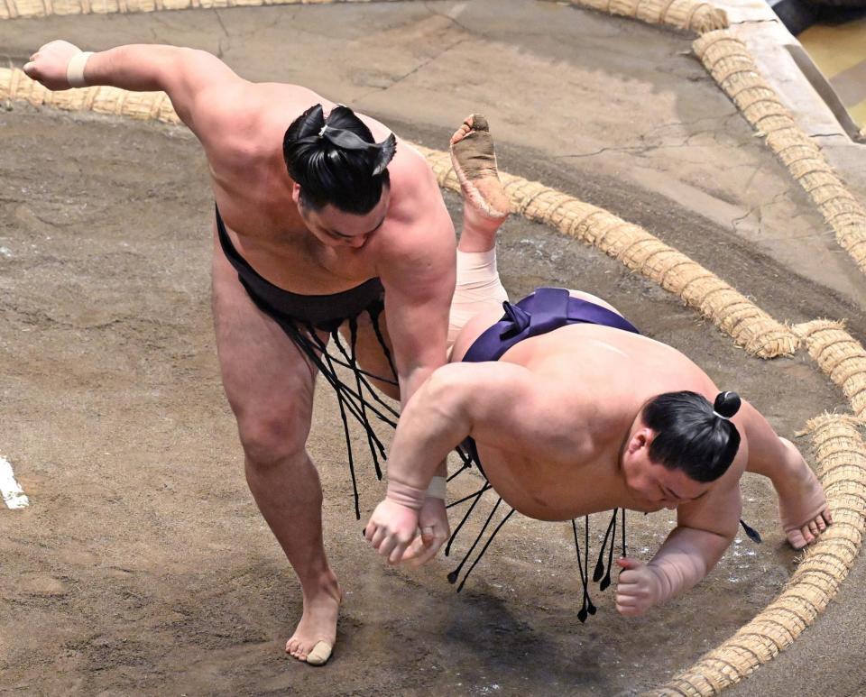 霧島（左）が上手投げで義ノ富士を下す